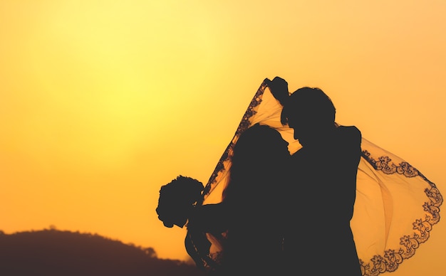 Silhouette di coppia in amore al tramonto.