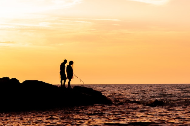 Silhouette di coppia sulla spiaggia con un bel tramonto