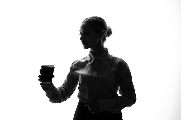 Silhouette di donna con consegna caffè nelle sue mani ombra retroilluminata giovane