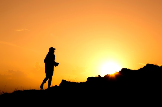 Silhouette di donne che camminano sulla collina al tramonto