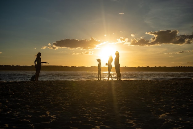 Silhouette di famiglia che gioca sulla spiaggia al tramonto