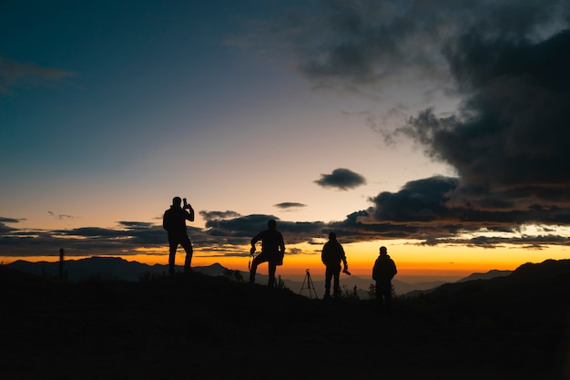 Silhouette di fotografi al tramonto