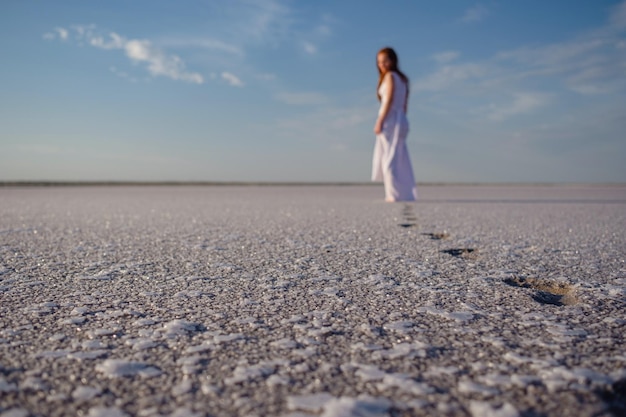 Silhouette di giovane donna che cammina sul Mar Morto all'alba Solitudine