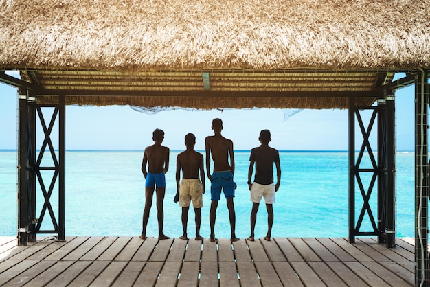 Silhouette di giovani ragazzi in un momento di relax in spiaggia in vacanza estiva