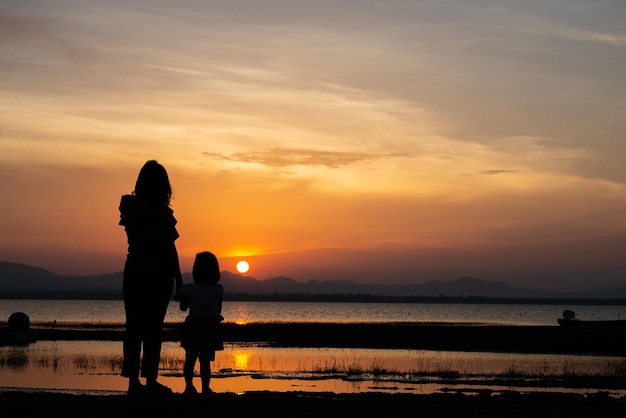 Silhouette di madre e figlia al tramontoPopolo della ThailandiaConcetto di famiglia feliceConcetto di festa della mamma