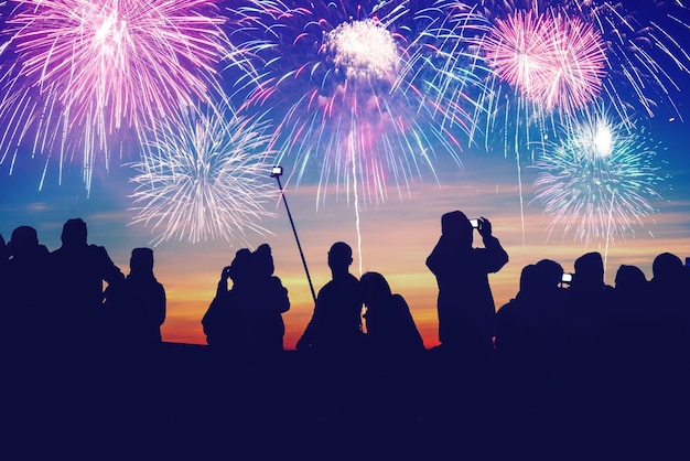 Silhouette di persone che guardano i fuochi d'artificio di notte