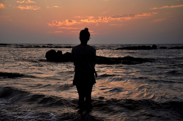 Silhouette di ragazza in piedi nel mare