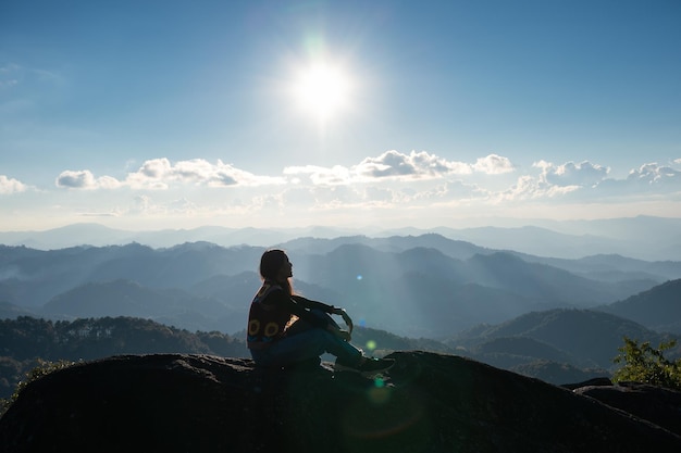 Silhouette di successo giovane escursionista donna rilassante e godersi la vista del tramonto sulla cima del picco di montagna al parco nazionale