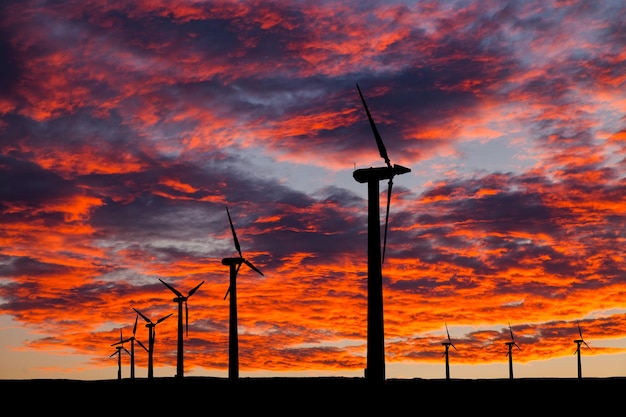 Silhouette di turbine eoliche su un tramonto incredibile