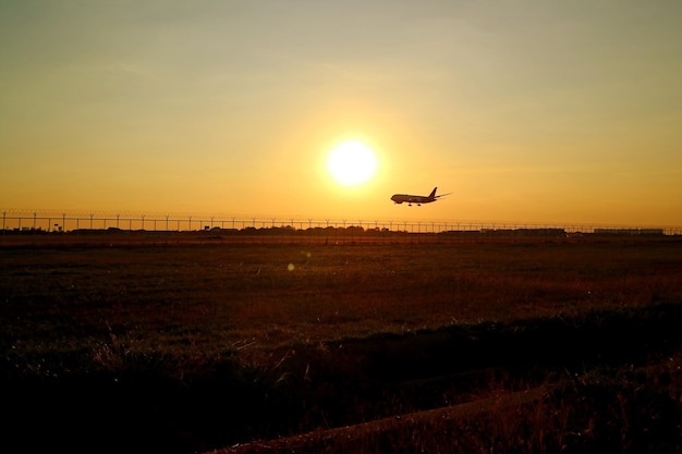 Silhouette di un aeroplano che vola contro il cielo al tramonto