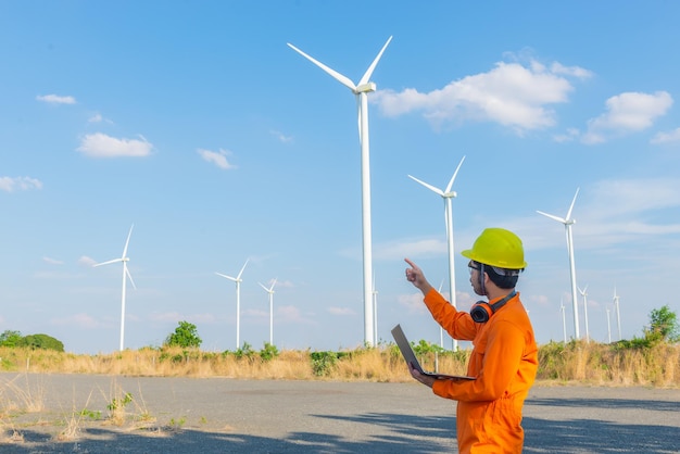 Silhouette di un ingegnere che lavora e tiene il rapporto presso l'azienda agricola di turbine eoliche Power Generator Station su mountainThailand persone