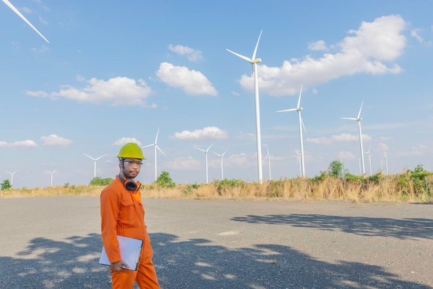 Silhouette di un ingegnere che lavora e tiene il rapporto presso l'azienda agricola di turbine eoliche Power Generator Station su mountainThailand persone