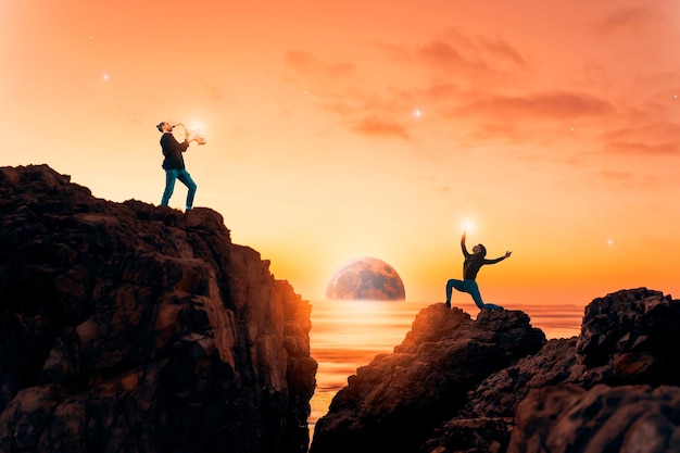 Silhouette di un musicista che suona il sassofono e una donna che balla sulle rocce al tramonto con la luna sullo sfondo