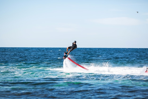 Silhouette di un pilota di flyboard in mare