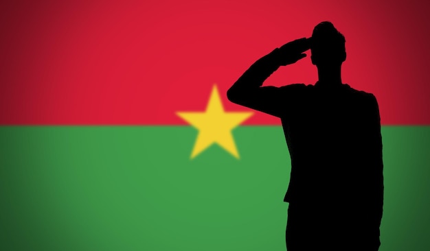 Silhouette di un soldato che saluta contro la bandiera del Burkina Faso