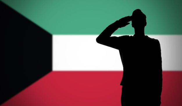 Silhouette di un soldato che saluta contro la bandiera del Kuwait