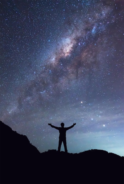 Silhouette di un uomo in piedi contro il campo stellato di notte