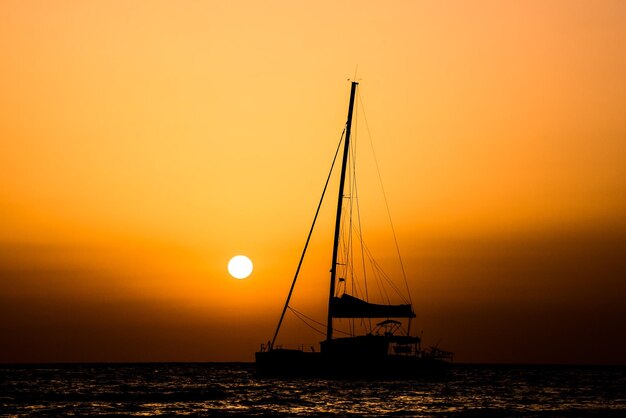 Silhouette di una barca a vela al tramonto