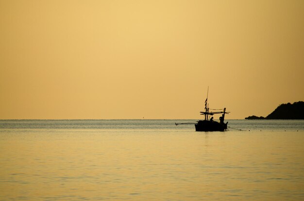 Silhouette di una barca a vela in mare contro il cielo durante il tramonto