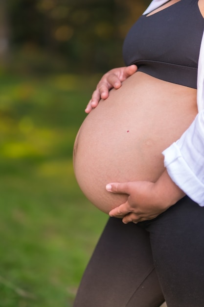 Silhouette di una donna incinta nel nono mese di gravidanza, sessione di gravidanza in una foresta