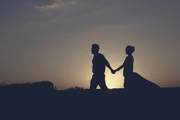 Silhouette di una giovane coppia romantica sulla spiaggia