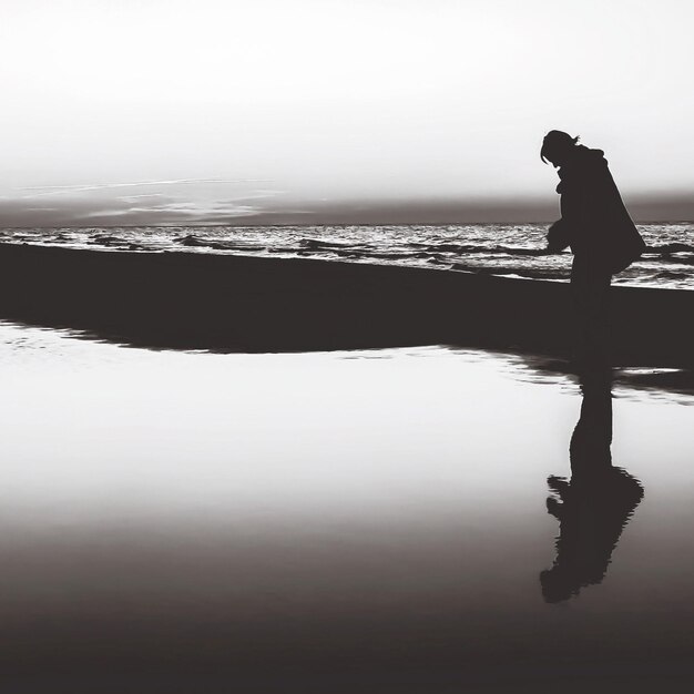 Silhouette di una persona in piedi sulla spiaggia