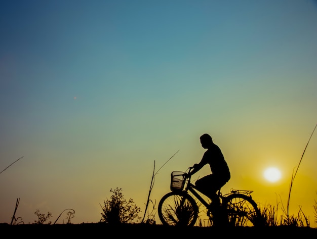 silhouette di una ragazza che corre su un sentiero con la sua moto.