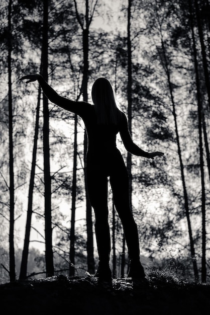 Silhouette di una ragazza con un bel corpo nella foresta