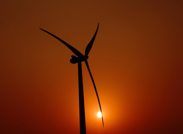 Foto silhouette di una turbina eolica contro un cielo arancione