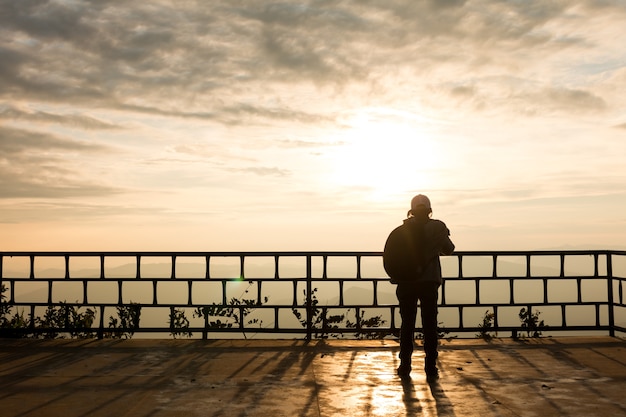 Silhouette di viaggiatore su sfondo bellissimo tramonto