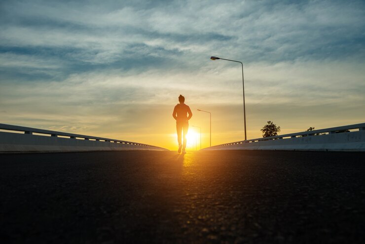 Silhouette donna che cammina per strada al tramonto.