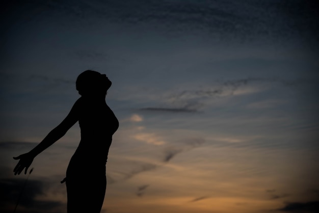 Silhouette donna felice e tramonto