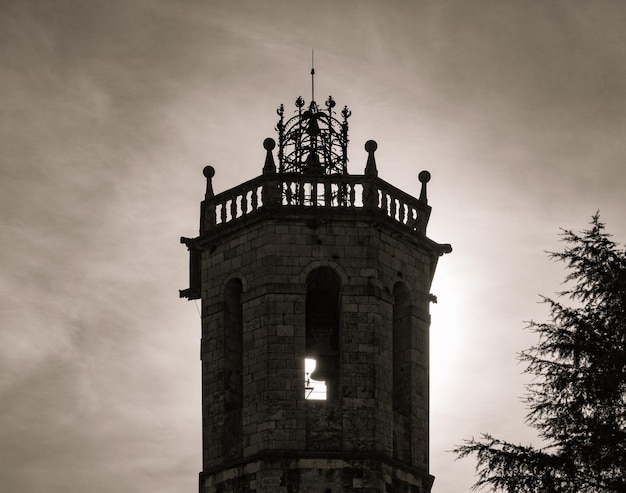 Silhouette e dettaglio del campanile della chiesa di centelles con luce drammatica