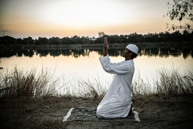 Silhouette Giovane uomo musulmano asiatico che prega sul concetto di festival del tramontoRamadan