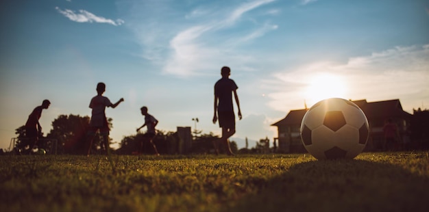 Silhouette sport d'azione all'aperto di bambini che si divertono a giocare a calcio