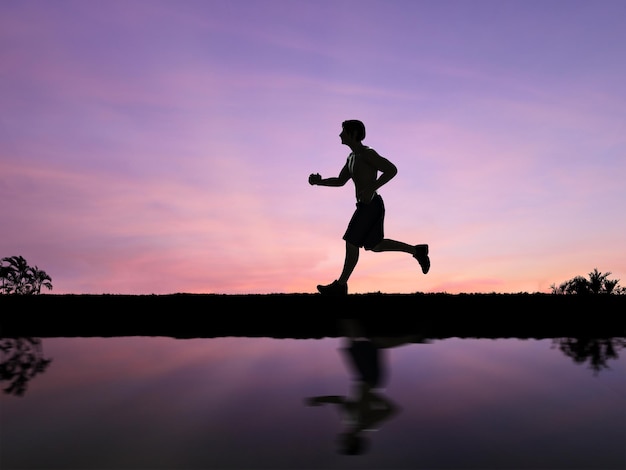 Silhouette uomo che fa jogging con lo sfondo del cielo al crepuscolo