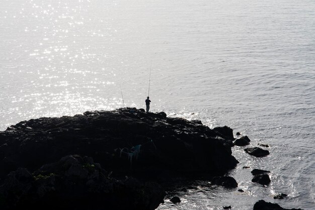 Silhouette uomo che pesca in mare