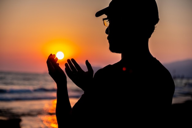 Silhouette uomo che prega per Allah