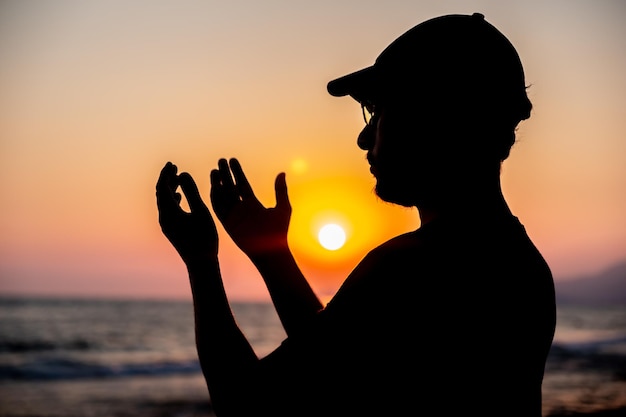 Silhouette uomo che prega per Allah