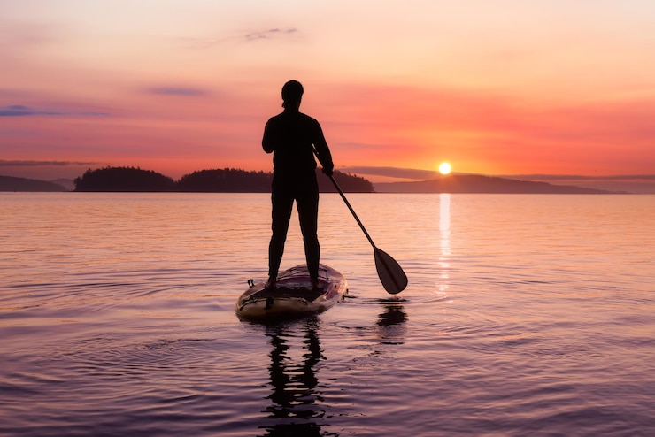 Foto silhouette uomo in piedi in mare contro il cielo durante il tramonto
