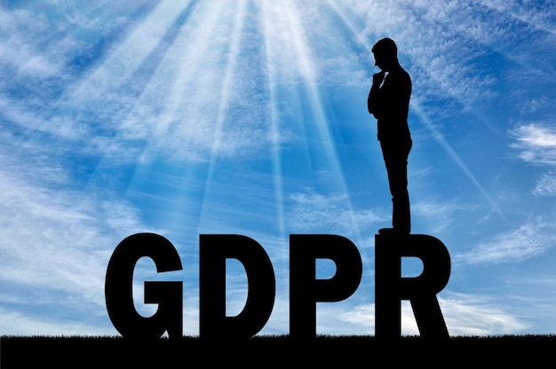 Silhouette uomo pensieroso in piedi sulla parola GDPR. Immagine concettuale sulla legge GDPR