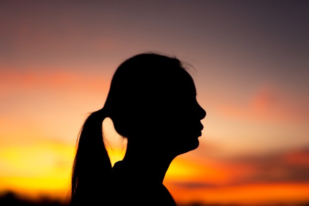 Silhouette volto di donne tristi e depresse del parco con il tramonto