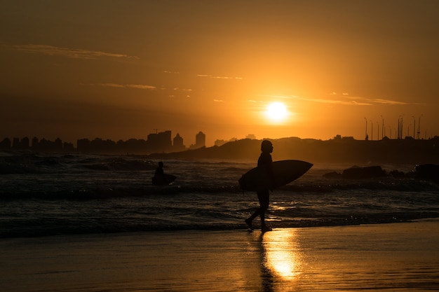 Silhoutte del surfista in spiaggia