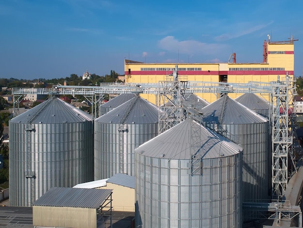 Silo agricolo Stoccaggio ed essiccazione di chicchi di mais grano soia contro il cielo blu con nuvole