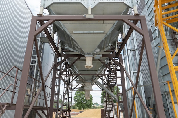 Silos d'argento su impianto agro manifatturiero per la lavorazione essiccazione pulitura e stoccaggio di prodotti agricoli farina cereali e grano Grandi botti di ferro di grano Elevatore granaio