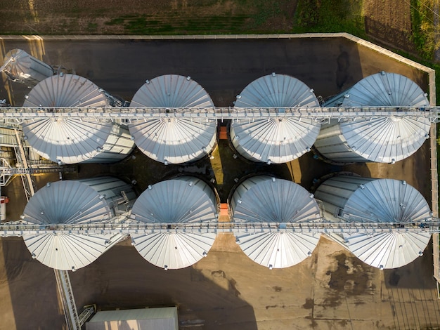 Silos d'argento su un impianto di produzione agricola per la lavorazione, l'essiccazione, la pulizia e lo stoccaggio di prodotti agricoli, farina, cereali e grano.