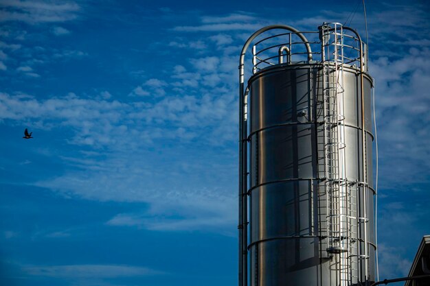 Silos in acciaio inossidabile nell'industria chimica silo in plastica sfusa contro un sole arancione