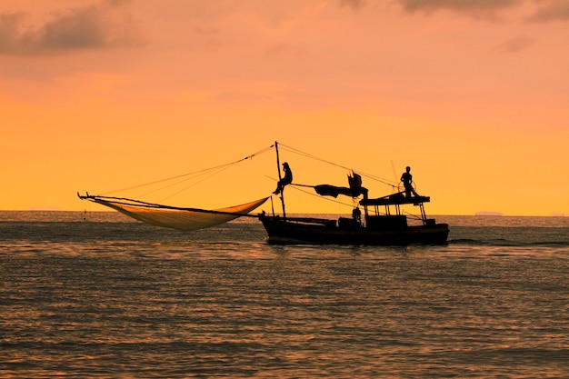 Siluetta della barca da pesca domestica in Tailandia contro il bellissimo cielo al tramonto