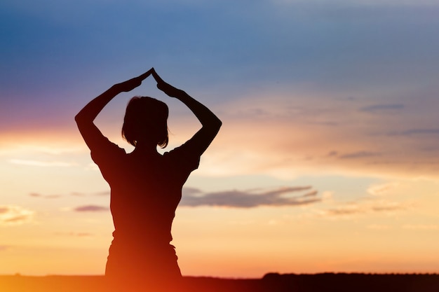 Siluetta della donna che posa al tramonto