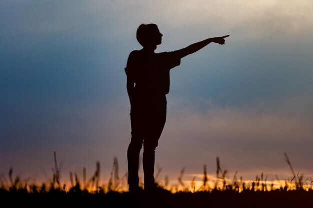 Siluetta della donna che posa al tramonto